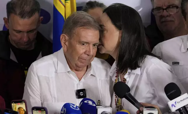 Opposition leader Maria Corina Machado talks to presidential candidate Edmundo Gonzalez during a press conference after electoral authorities declared President Nicolas Maduro the winner of the presidential election in Caracas, Venezuela, Monday, July 29, 2024. (AP Photo/Matias Delacroix)