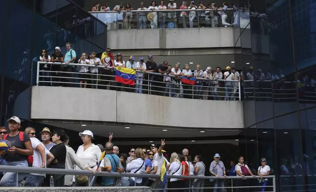 Opposition supporters protest the reelection of President Nicolás Maduro one month after the disputed vote, which opposition leaders claim they won by a landslide, at a shopping mall in Caracas, Venezuela, Wednesday, Aug. 28, 2024. (AP Photo/Cristian Hernandez)