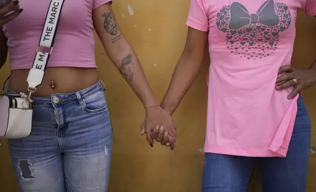 Franchesca Aponte, left, and her mother Lili Martínez hold hands outside the Boleita National Police detention center after their brother and son was arrested during recent opposition protests against the official results of the presidential election in Caracas, Venezuela, Thursday, Aug. 1, 2024. (AP Photo/Matias Delacroix)