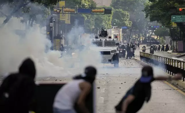 Protesters clash with police during demonstrations against the official election results declaring President Nicolas Maduro's reelection, the day after the vote in Caracas, Venezuela, Monday, July 29, 2024. (AP Photo/Matias Delacroix)