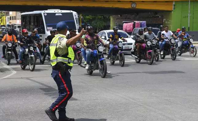 A police officer directs traffic while the traffic lights are out in Valencia, Venezuela, Friday, Aug. 30, 2024, during a blackout that affected most of the country. (AP Photo/Jacinto Olivares)