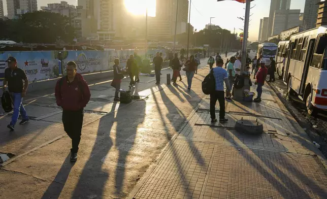 Commuters walk during a blackout in Caracas, Venezuela, early Friday, Aug. 30, 2024. (AP Photo/Ariana Cubillos)