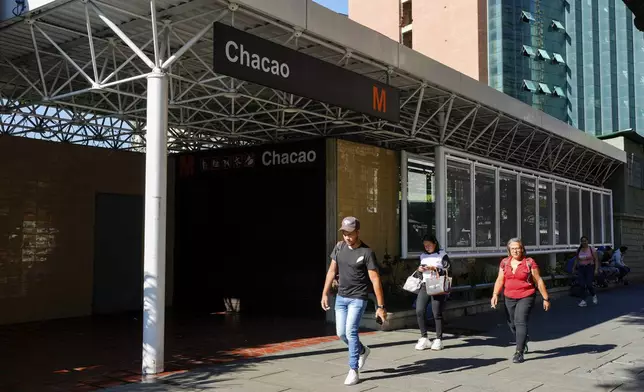 Pedestrians walk past a closed metro station during a blackout in Caracas, Venezuela, Friday, Aug. 30, 2024. (AP Photo/Ariana Cubillos)