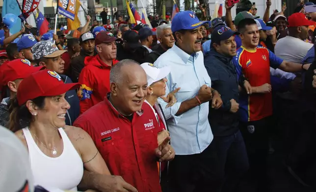 Venezuelan President Nicolas Maduro, center, accompanied by lawmaker Diosdado Cabello, second left, first lady Cilia Flores march in a pro-government rally, in Caracas, Venezuela, Saturday, Aug. 17, 2024. (AP Photo/Cristian Hernandez )