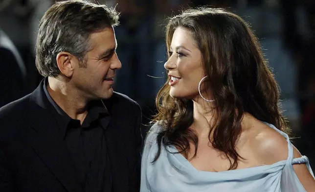 FILE - US actor George Clooney, left, and Welsh actress Catherine Zeta-Jones appear at the screening of their film "Intolerable Cruelty" out of competition at the 60th Venice Film Festival in Venice, Italy, Wednesday, Sept. 3, 2003. (AP Photo/Luca Bruno, File)