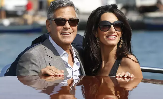 FILE - George Clooney, left, and Amal Alamuddin arrive in Venice, Italy, on Sept. 26, 2014, for their upcoming wedding. (AP Photo/Luca Bruno, File)