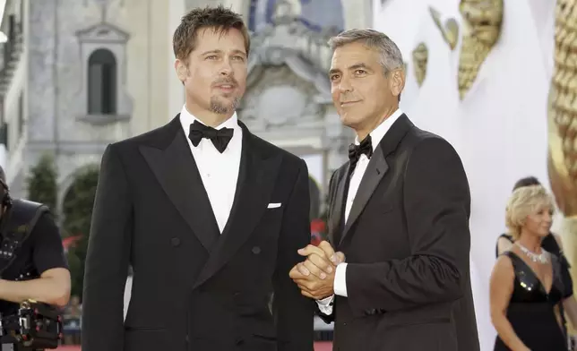 FILE - Actors Brad Pitt, left, and George Clooney appear at the screening of the movie "Burn After Reading," opening the 65th edition of the Venice Film Festival in Venice, Italy on Aug. 27, 2008. (AP Photo/Joel Ryan, File)