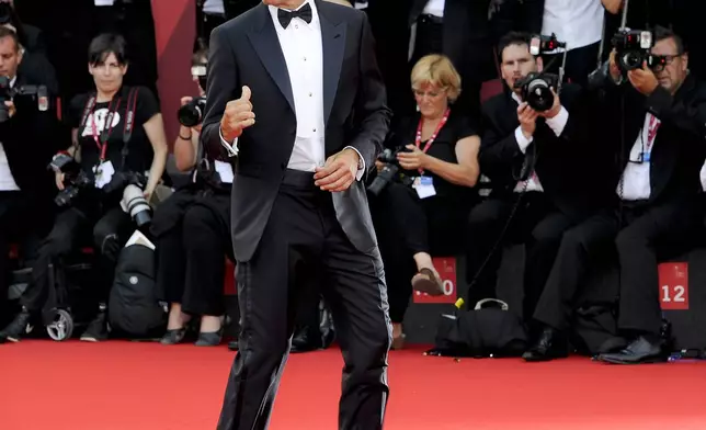 FILE - US actor George Clooney arrives on the red carpet for the premiere of his movie "The Ides of March," opening the 68th edition of the Venice Film Festival in Venice, Italy on Aug. 31, 2011. (AP Photo/Jonathan Short, File)