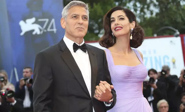 FILE - George Clooney, left, and Amal Clooney appear at the premiere of the film "Suburbicon" during the 74th edition of the Venice Film Festival in Venice, Italy on Sept. 2, 2017. (Photo by Joel Ryan/Invision/AP, File)