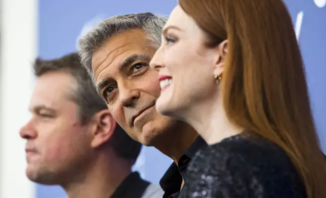 FILE - Actor George Clooney, center, poses with actors, Julianne Moore, right, and Matt Damon during the photo call for the film "Suburbicon" at the 74th Venice Film Festival in Venice, Italy on Sept. 2, 2017. (AP Photo/Domenico Stinellis, File)