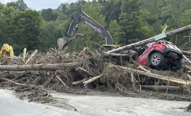 Crews clean up debris from flash floods in Lyndonville, Vt., Wednesday, July 31, 2024. Parts of the state hit by flooding Monday night and Tuesday are bracing again as a new round of severe thunderstorms moves through the region. (AP Photo/Nick Perry)