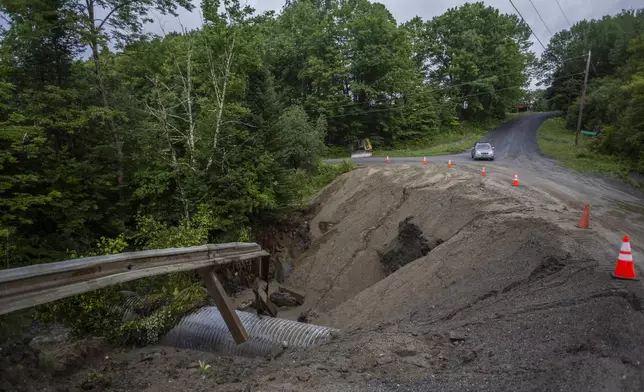 Cones guard a washed out roadway in the aftermath of flash floods in Lyndonville, Vermont, Wednesday, July 31, 2024. (AP Photo/Dmitry Belyakov)