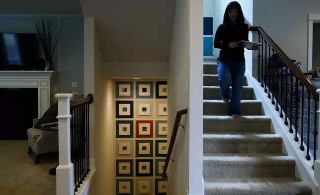 Ellen Lo Hoffman, the co-founder of Soul Reparations, a nonprofit providing free spiritual support to women, walks down the stairs at her home Wednesday, Aug. 21, 2024, in Bothell, Wash. (AP Photo/Lindsey Wasson)