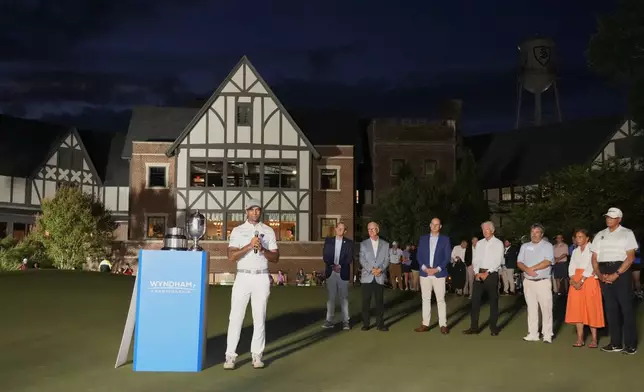 Aaron Rai, of England, center, speaks during the award ceremony after winning the Wyndham Championship golf tournament in Greensboro, N.C., Sunday, Aug. 11, 2024. (AP Photo/Chuck Burton)