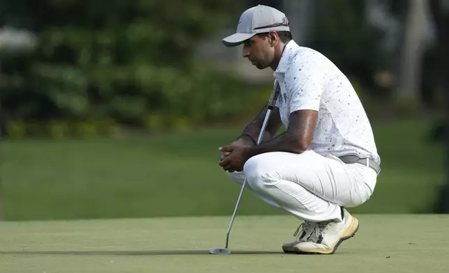 Aaron Rai, of England, lines up a putt on the ninth hole during the final round of the Wyndham Championship golf tournament in Greensboro, N.C., Sunday, Aug. 11, 2024. (AP Photo/Chuck Burton)