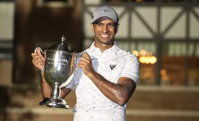 Aaron Rai, of England, poses with the trophy after winning the Wyndham Championship golf tournament in Greensboro, N.C., Sunday, Aug. 11, 2024. (AP Photo/Chuck Burton)