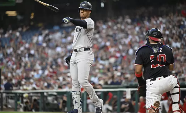 Washington Nationals catcher Keibert Ruiz, right, turn towards the dugout as New York Yankees' Juan Soto tosses his bat after striking outdoor in the final out of the third inning of a baseball game, Tuesday, Aug. 27, 2024, in Washington. (AP Photo/John McDonnell)