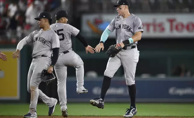 New York Yankees' Juan Soto, left, Gleyber Torres, center, and Aaron Judge, right, celebrate after a baseball game against the Washington Nationals, Monday, Aug. 26, 2024, in Washington. The Yankees won 5-2.(AP Photo/Nick Wass)