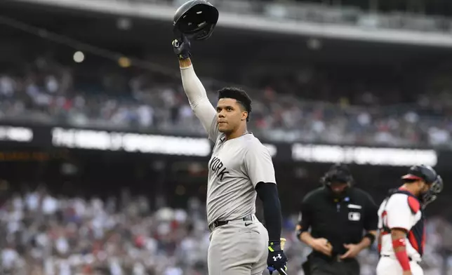 New York Yankees' Juan Soto doffs his batting helmet to the crowd during the first inning of a baseball game against the Washington Nationals, Monday, Aug. 26, 2024, in Washington. (AP Photo/Nick Wass)