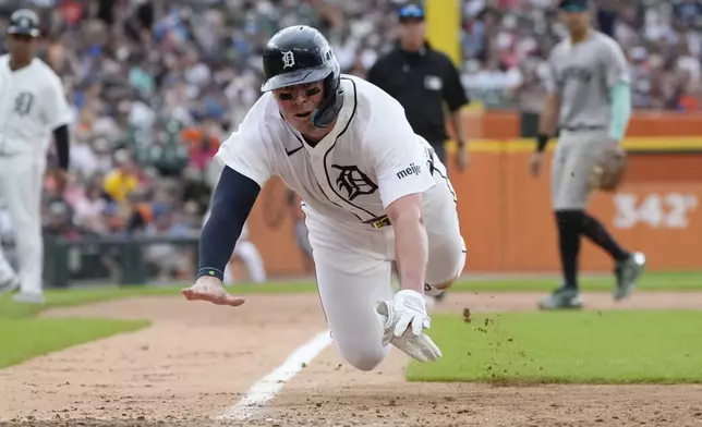 Detroit Tigers' Spencer Torkelson leaps towards home plate on a passed pitch during the sixth inning of a baseball game av], Saturday, Aug. 17, 2024, in Detroit. (AP Photo/Carlos Osorio)