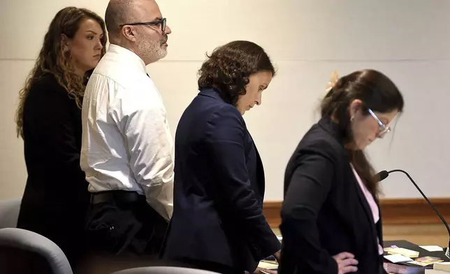 Victor Malavet, center, stands with his lawyers as the court clerk reads the charges against him during his trial at Merrimack County Superior Court in Concord, N.H., on Monday, Aug. 26, 2024. Malavet, a former state employee is charged in connection with the attorney general's probe of the Sununu Youth Services Center in Manchester. (David Lane/Union Leader via AP, Pool)