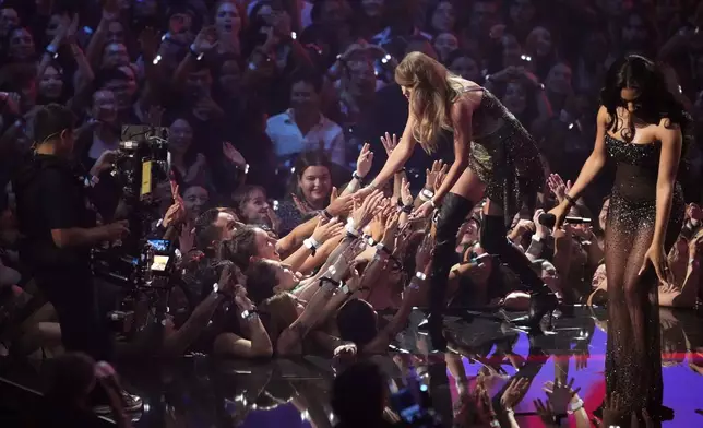 Taylor Swift, left, accepts the video of the year for "Fortnight" from Megan Thee Stallion during the MTV Video Music Awards on Wednesday, Sept. 11, 2024, at UBS Arena in Elmont, N.Y. (Photo by Charles Sykes/Invision/AP)