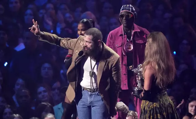 Post Malone, left, and Taylor Swift accept the award for best collaboration for "Fortnight"during the MTV Video Music Awards on Wednesday, Sept. 11, 2024, at UBS Arena in Elmont, N.Y. Jordan Chiles, back left, and Flava Flav look on.(Photo by Charles Sykes/Invision/AP)