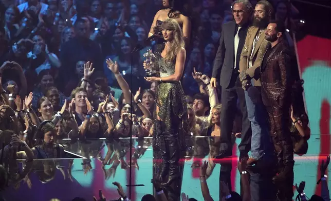 Taylor Swift, center, and Post Malone, third from back left, accept the video of the year award for "Fortnight" during the MTV Video Music Awards on Wednesday, Sept. 11, 2024, at UBS Arena in Elmont, N.Y. Host Megan Thee Stallion, from far left back, Rodrigo Prieto, and Ethan Tobman, far right, look on. (Photo by Charles Sykes/Invision/AP)