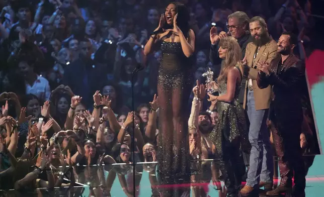 Taylor Swift, center, and Post Malone, third from back left, accept the video of the year award for "Fortnight" during the MTV Video Music Awards on Wednesday, Sept. 11, 2024, at UBS Arena in Elmont, N.Y. Host Megan Thee Stallion, from far left back, Rodrigo Prieto, and Ethan Tobman, far right, look on. (Photo by Charles Sykes/Invision/AP)