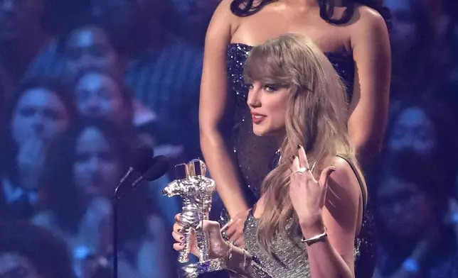 Taylor Swift accepts the video of the year award for "Fortnight" during the MTV Video Music Awards on Wednesday, Sept. 11, 2024, at UBS Arena in Elmont, N.Y. Megan Thee Stallion looks on from left. (Photo by Charles Sykes/Invision/AP)