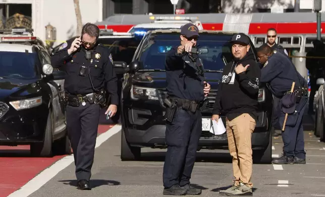 Police officers secure the area and investigate the scene of a shooting at Union Square in San Francisco on Saturday, Aug. 31, 2024. (Santiago Mejia/San Francisco Chronicle via AP)