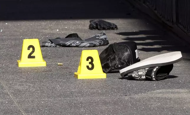 Blood and a shell casing is seen tagged as evidence as police officers secure the area and investigate the scene of a shooting at Union Square in San Francisco, Saturday, Aug. 31, 2024. San Francisco 49ers wide receiver Ricky Pearsall was shot Saturday during an attempted robbery, the city's mayor said. (Santiago Mejia/San Francisco Chronicle via AP)