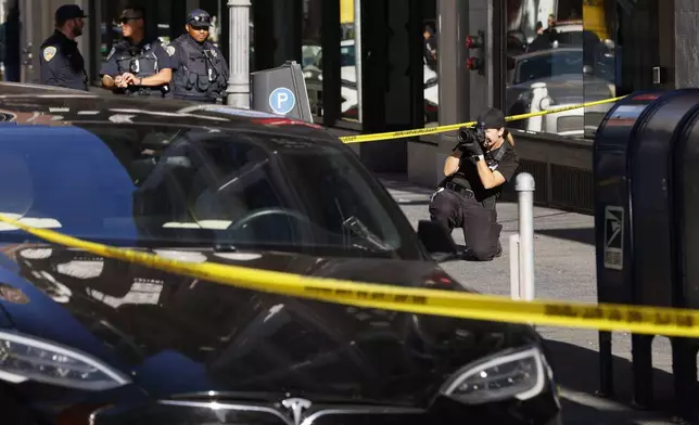 Police officers secure the area and investigate the scene of a shooting at Union Square in San Francisco, Saturday, Aug. 31, 2024. (Santiago Mejia/San Francisco Chronicle via AP)