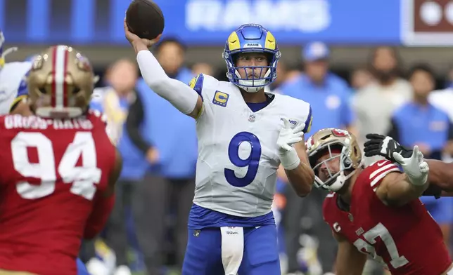 Los Angeles Rams quarterback Matthew Stafford (9) passes between San Francisco 49ers defensive end Yetur Gross-Matos (94) and defensive end Nick Bosa during the first half of an NFL football game, Sunday, Sept. 22, 2024, in Inglewood, Calif. (AP Photo/Ryan Sun)