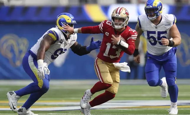 San Francisco 49ers quarterback Brock Purdy (13) runs against Los Angeles Rams defensive tackle Kobie Turner, left, and defensive tackle Braden Fiske (55) during the second half of an NFL football game, Sunday, Sept. 22, 2024, in Inglewood, Calif. (AP Photo/Ryan Sun)