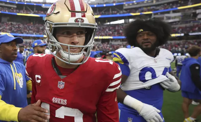 San Francisco 49ers quarterback Brock Purdy, foreground left, walks off the next next to Los Angeles Rams defensive end Desjuan Johnson after an NFL football game, Sunday, Sept. 22, 2024, in Inglewood, Calif. (AP Photo/Ryan Sun)