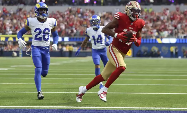 San Francisco 49ers wide receiver Jauan Jennings, right, scores a touchdown past Los Angeles Rams safety Kamren Kinchens (26) and cornerback Cobie Durant (14) during the second half of an NFL football game, Sunday, Sept. 22, 2024, in Inglewood, Calif. (AP Photo/Ryan Sun)