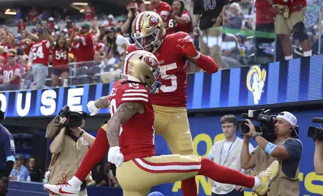 San Francisco 49ers wide receiver Jauan Jennings, top middle, is congratulated by wide receiver Ronnie Bell after scoring against the Los Angeles Rams during the second half of an NFL football game, Sunday, Sept. 22, 2024, in Inglewood, Calif. (AP Photo/Ryan Sun)