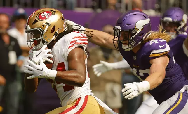 San Francisco 49ers running back Jordan Mason (24) runs from Minnesota Vikings linebacker Andrew Van Ginkel (43) during the first half of an NFL football game, Sunday, Sept. 15, 2024, in Minneapolis. (AP Photo/Bruce Kluckhohn)