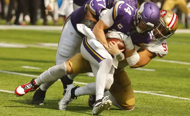 Minnesota Vikings quarterback Sam Darnold (14) is sacked by San Francisco 49ers defensive end Nick Bosa (97) during the second half of an NFL football game, Sunday, Sept. 15, 2024, in Minneapolis. (AP Photo/Bruce Kluckhohn)