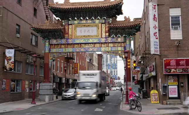 People pass through the Chinatown neighborhood of Philadelphia, Wednesday, Sept. 18, 2024. (AP Photo/Matt Slocum)