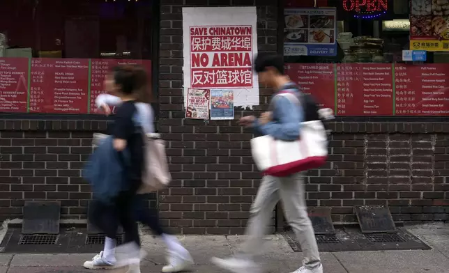 People walk through the Chinatown neighborhood of Philadelphia, Wednesday, Sept. 18, 2024. (AP Photo/Matt Slocum)