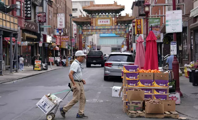 A man walks through the Chinatown neighborhood of Philadelphia, Wednesday, Sept. 18, 2024. (AP Photo/Matt Slocum)