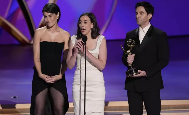 Jen Statsky, from left, Lucia Aniello, and Paul W. Downs accept the award for outstanding writing for a comedy series for "Hacks" during the 76th Primetime Emmy Awards on Sunday, Sept. 15, 2024, at the Peacock Theater in Los Angeles. (AP Photo/Chris Pizzello)