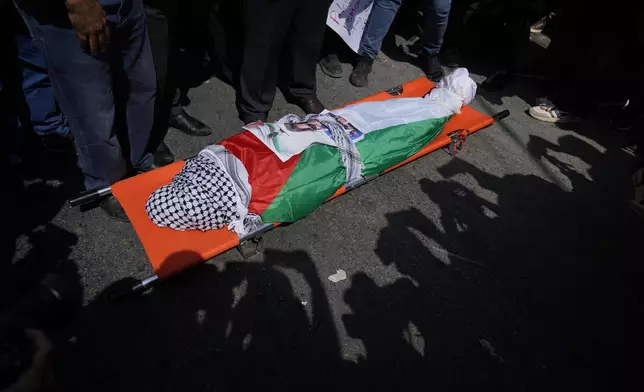 ADDS WITNESS SAYS: Mourners pray over the body of Aysenur Ezgi Eygi, 26, who a witness says was fatally shot by Israeli soldiers while participating in an anti-settlement protest in the West Bank, during her funeral procession in the West Bank city of Nablus, Monday, Sept. 9, 2024. (AP Photo/Nasser Nasser)