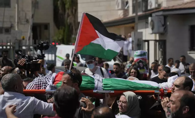 ADDS WITNESS SAYS: Mourners carry the body of Aysenur Ezgi Eygi, 26, who a witness says was fatally shot by Israeli soldiers while participating in an anti-settlement protest in the West Bank, during her funeral procession in the West Bank city of Nablus, Monday, Sept. 9, 2024. (AP Photo/Nasser Nasser)