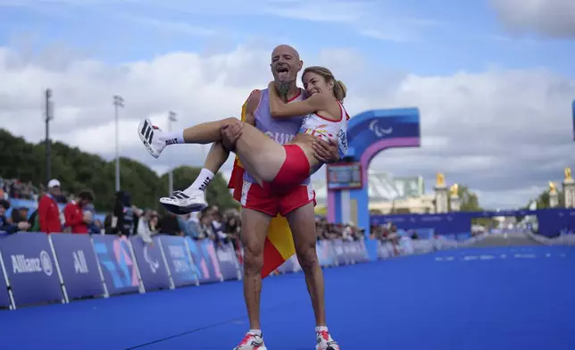 ADDITION ELENA CONGOST WAS DISQUALIFIED FOR LETTING GO OF THE ROPE TO HELP HER GUIDE - Spain's Elena Congost celebrates with his guide as she arrives in third position in the women's marathon T12 at the 2024 Paralympics, Sunday, Sept. 8, 2024, in Paris, France. (AP Photo/Thibault Camus)