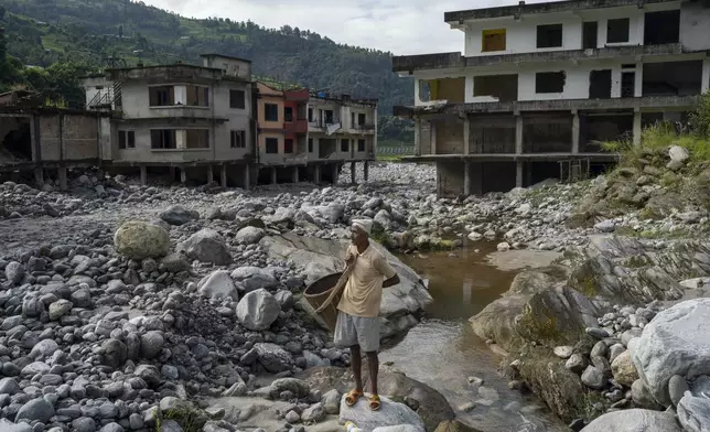 Kali Prasad Shrestha, 57, stands near Kathmandu, Nepal, Sunday, Sept. 15, 2024, on the spot where his house once stood before it was swept away by floods in 2021.(AP Photo/Niranjan Shrestha)