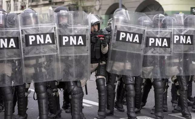 Police guard Congress during protests against President Javier Milei's veto of a pension raise in Buenos Aires, Argentina, Wednesday, Sept. 11, 2024. (AP Photo/Rodrigo Abd)