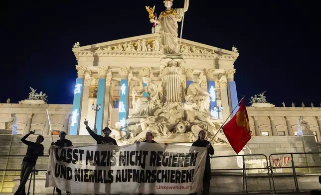 Anti right wing protesters shout slogans and hold an banner that reads "Don't let Nazis rule and never let them march" in front of the parliament building, in Vienna, Austria, Sunday, Sept. 29, 2024, after polls closed in the country's national election. (AP Photo/Andreea Alexandru)